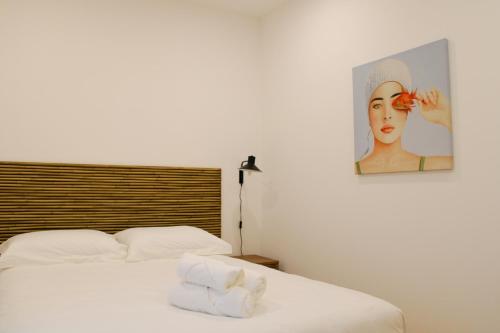 1 dormitorio con 2 camas y una foto de una mujer en Casa dos Cucos, en Ericeira