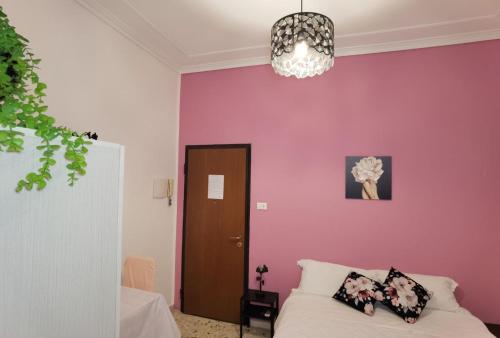 um quarto com uma parede roxa com uma cama e um lustre em Luxury Sisters House "La Buganvilla" em Catânia