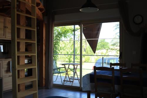 a room with a glass door leading to a patio at Les Glycines de Soubize in Lablachère