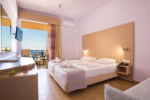 a hotel room with two beds and a television at Atlantis Hotel in Karpathos