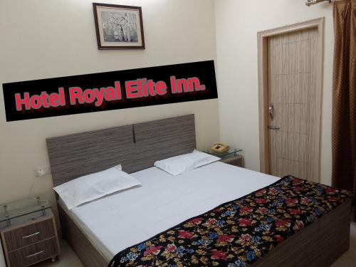 1 cama en una habitación con un cartel de la posada de élite real del hotel en The Royal Elite Guest House, en Jalandhar