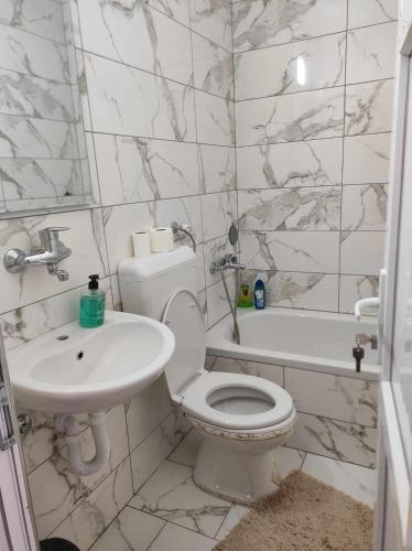 a white bathroom with a toilet and a sink at Motel BI in Bijeljina
