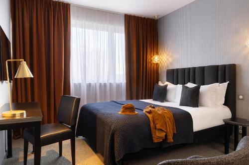 a hotel room with a bed and a desk and a chair at Best Western Plus Hôtel Isidore in Saint-Jacques-de-la-Lande