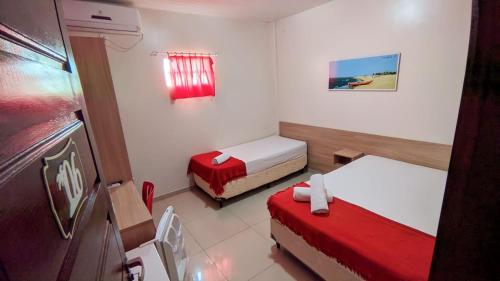 ルイース・コヘイアにあるPousada Tianguáのベッド2台と窓が備わる小さな客室です。