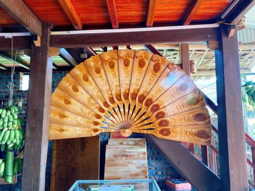 a large wooden fan hanging from the ceiling of a store at Homestay Chinh Bi in Yên Bái