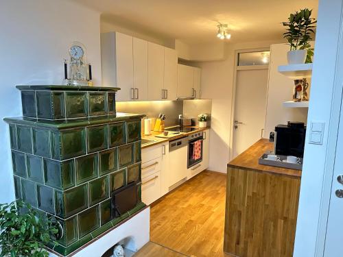 a large kitchen with white cabinets and a counter at The Peaceful Garden Stay & Free Parking in Salzburg