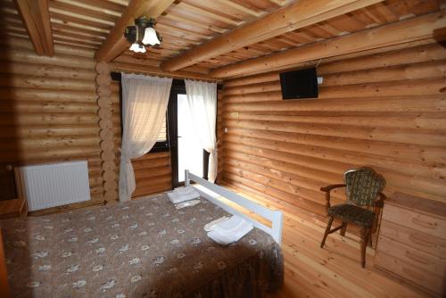ベレホヴェにあるСадиба Арсентійのログキャビン内のベッドルーム(ベッド1台、椅子付)