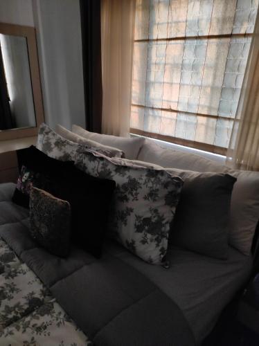 a couch with pillows sitting in front of a window at The Beach House in Chennai