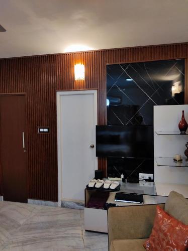 a living room with a white door and a piano at The Beach House in Chennai