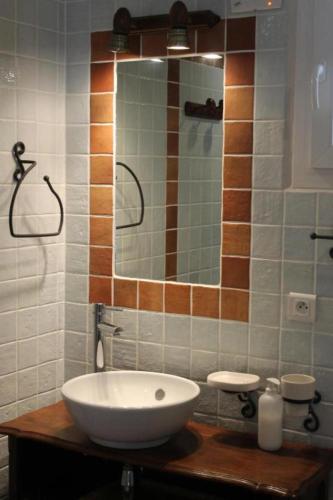une salle de bain avec un lavabo et un miroir dans l'établissement Bastidon les Oliviers, à Belgentier