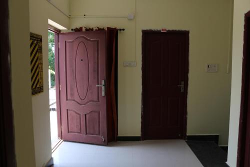 two doors are open in a room at Renu Residency on the way to Isha Yoga Centre- Adiyogi near Maruthamalai in Marudhamalai
