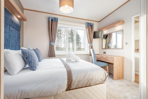 a bedroom with a large bed and a desk at Lodge 82 The Lyndale 10 minute drive to St Andrews in Cameron
