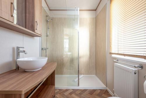 a bathroom with a sink and a glass shower at Lodge 82 The Lyndale 10 minute drive to St Andrews in Cameron
