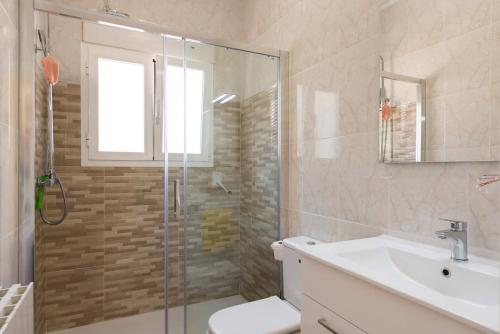a bathroom with a shower and a toilet and a sink at Villa Amelia - PlusHolidays in Ifach