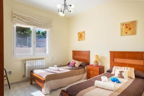 1 dormitorio con 2 camas y ventana en Villa Amelia - PlusHolidays, en Calpe