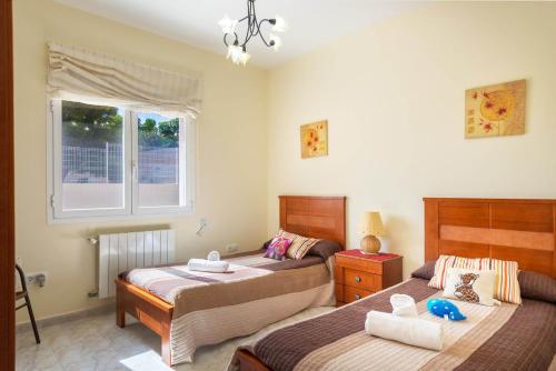 a bedroom with two beds and a window at Villa Amelia - PlusHolidays in Calpe