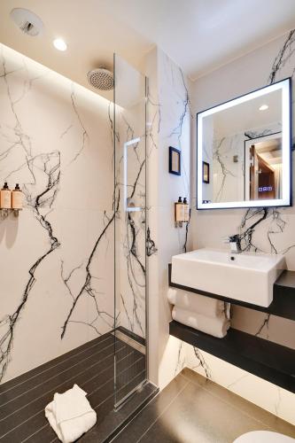 a bathroom with a sink and a shower at CARD Hôtel in Paris
