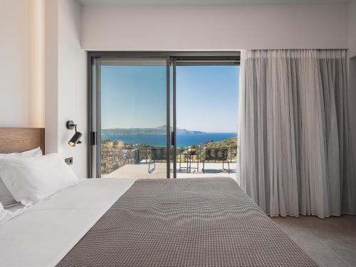 a bedroom with a bed and a view of the ocean at Brand new Villa Eleftheria BY APOKORONAS-VILLAS in Plaka