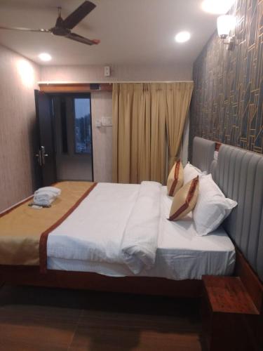 布巴內斯瓦爾的住宿－Hotel Stalwart Jajati，卧室配有一张带白色床单和枕头的大床。
