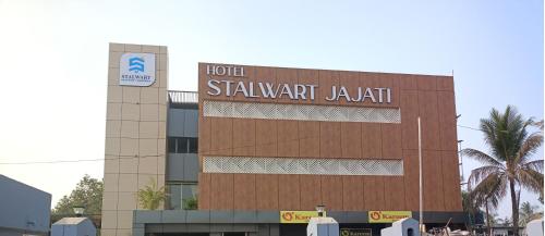 ein Hotel mit einem Schild auf einem Gebäude in der Unterkunft Hotel Stalwart Jajati in Bhubaneshwar
