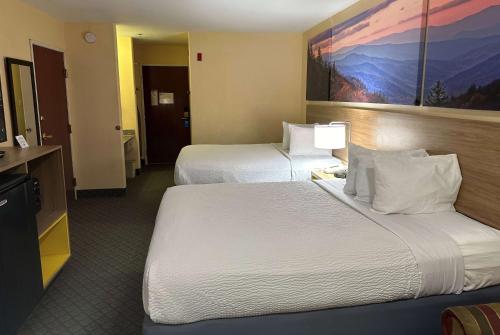 a hotel room with two beds and a television at Days Inn & Suites by Wyndham Eunice in Eunice