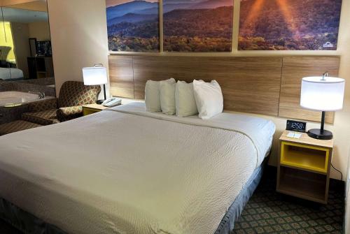 a hotel room with a large bed and a bathroom at Days Inn & Suites by Wyndham Eunice in Eunice