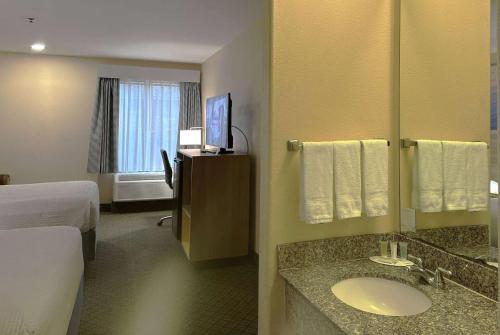 Habitación de hotel con baño con lavabo en Days Inn & Suites by Wyndham Eunice, en Eunice