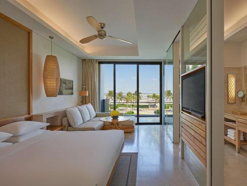 um quarto com uma cama, uma televisão e uma sala de estar em Hyatt Regency Danang Resort and Spa em Da Nang