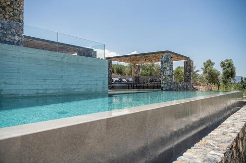 a swimming pool in a house with a stone wall at Brand new Villa Eleftheria BY APOKORONAS-VILLAS in Plaka