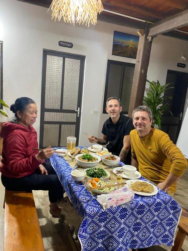 a group of people sitting around a table eating food at Homestay Chinh Bi in Yên Bái