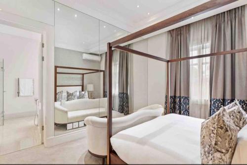 una camera con letto a baldacchino e specchio di The White House a Johannesburg
