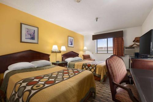 a hotel room with two beds and a flat screen tv at Super 8 by Wyndham Brookville in Brookville