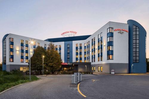 a large building with a parking lot in front of it at Vienna House Easy by Wyndham Bratislava in Bratislava