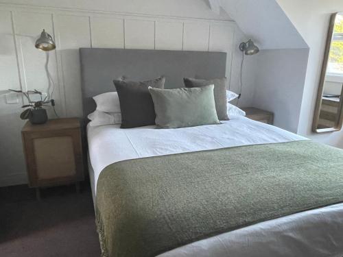 1 dormitorio con 1 cama grande con sábanas y almohadas blancas en Falmouth Bay en Falmouth