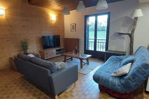 ein Wohnzimmer mit einem Sofa und einem TV in der Unterkunft Belle maison de 140 m2 in Villard-de-Lans