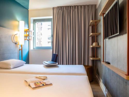 a hotel room with two beds and a laptop on top at ibis budget Paris Clichy Mairie in Clichy