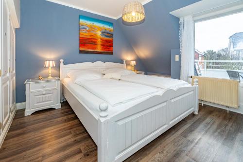 a large white bed in a room with a window at Haus Tinchen in Westerland (Sylt)