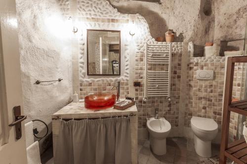 a bathroom with a sink and a toilet and a mirror at Il Tempo Ritrovato in Matera
