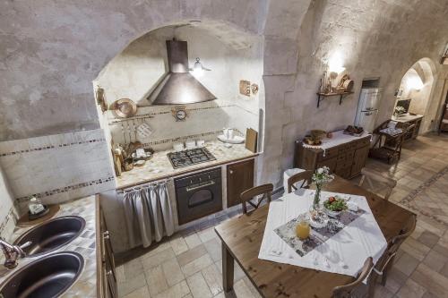 a kitchen with a table and a stove and a sink at Il Tempo Ritrovato in Matera