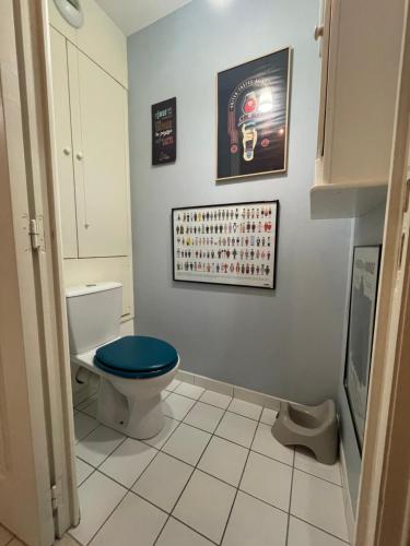 La salle de bains est pourvue de toilettes avec un siège bleu. dans l'établissement Villa Louise - Appartement Spacieux proche digue avec jardin, à Wimereux