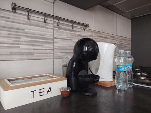 a kitchen counter with a tea mixer and a bottle of water at Novi Outlet Apartment in Novi Ligure