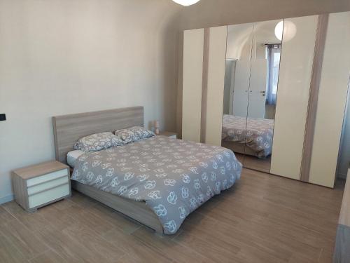 1 dormitorio con cama y espejo grande en Novi Outlet Apartment en Novi Ligure
