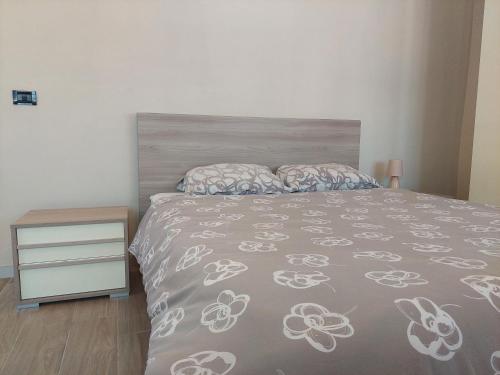 a bedroom with a bed and a dresser in it at Novi Outlet Apartment in Novi Ligure