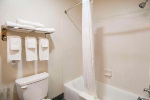a bathroom with a toilet and a shower with towels at Sleep Inn & Suites in Tuscaloosa