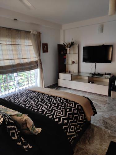 a bedroom with a bed and a flat screen tv at The Beach House in Chennai