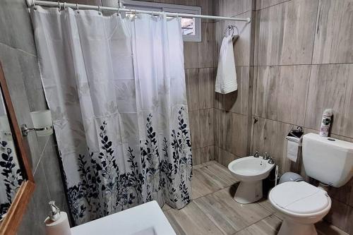 a bathroom with a toilet and a shower curtain at Departamentos Muy Eugenia in San Rafael