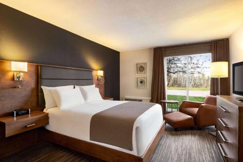 a hotel room with a bed and a window at Atlantic Host Hotel, Trademark Collection by Wyndham in Bathurst