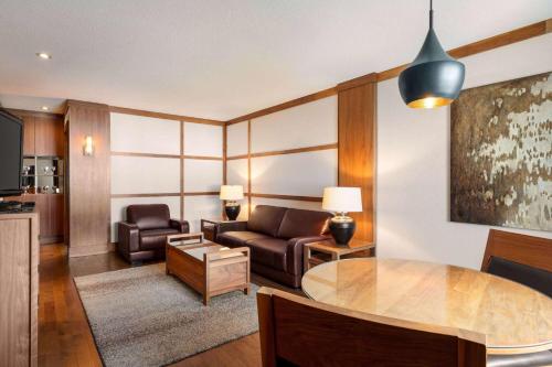 a living room with a couch and a table at Atlantic Host Hotel, Trademark Collection by Wyndham in Bathurst