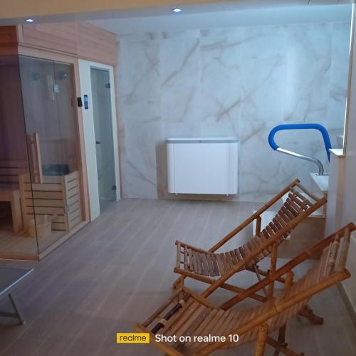 a room with two chairs and a television in it at mya luxury rooms and wellness in Melendugno