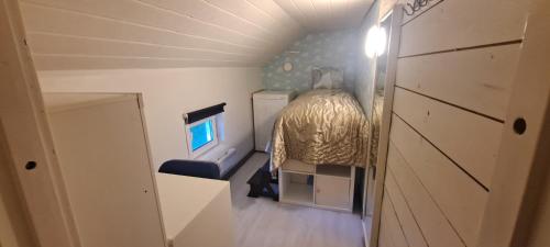 ein kleines Schlafzimmer mit einem Bett in einem winzigen Haus in der Unterkunft Zimmer in Möbilierter Wohnung in Kaarina
